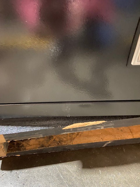 Dent and scratched below bottom drawer